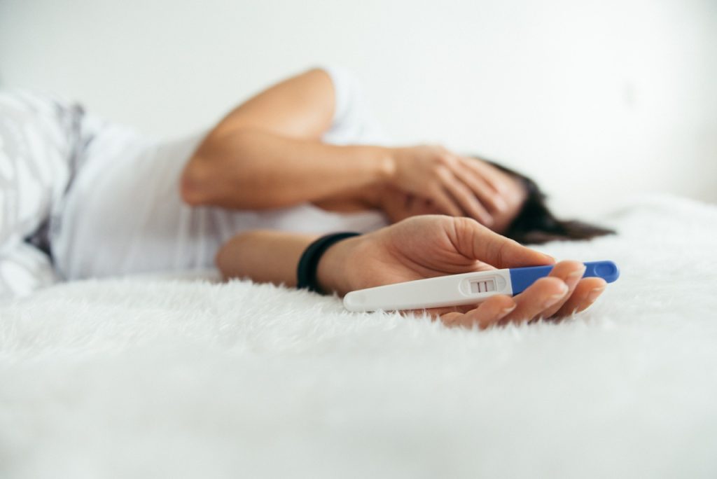 A woman looking at a pregnancy test with concern while navigating fertility after 35.
