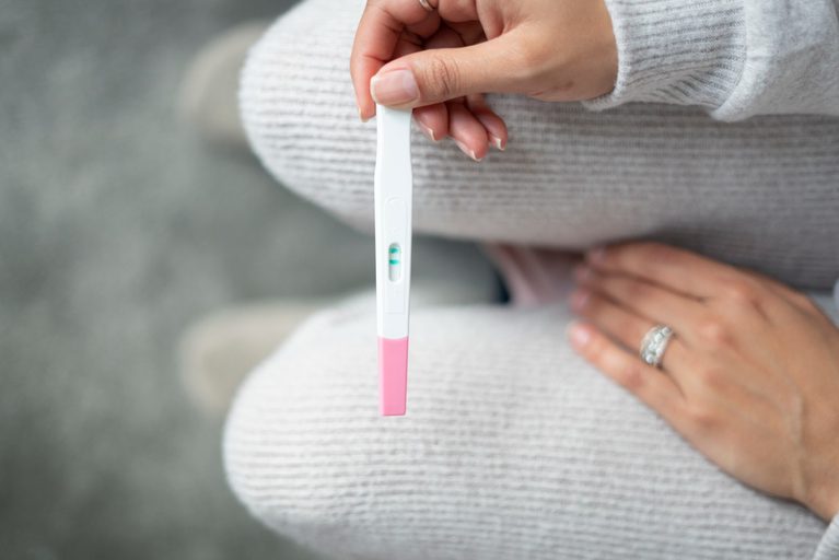 Expectant mother holding a positive pregnancy test, highlighting pregnancy after 35 and prenatal care.