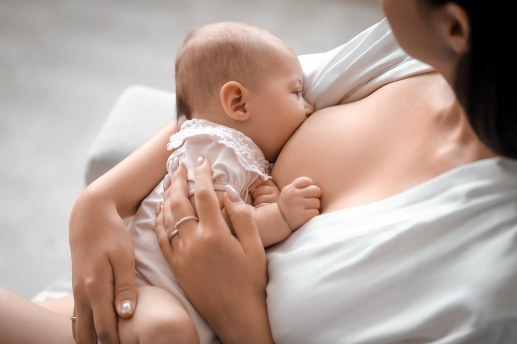 Mother breastfeeding her infant baby, illustrating breastfeeding support at home and in the workplace.