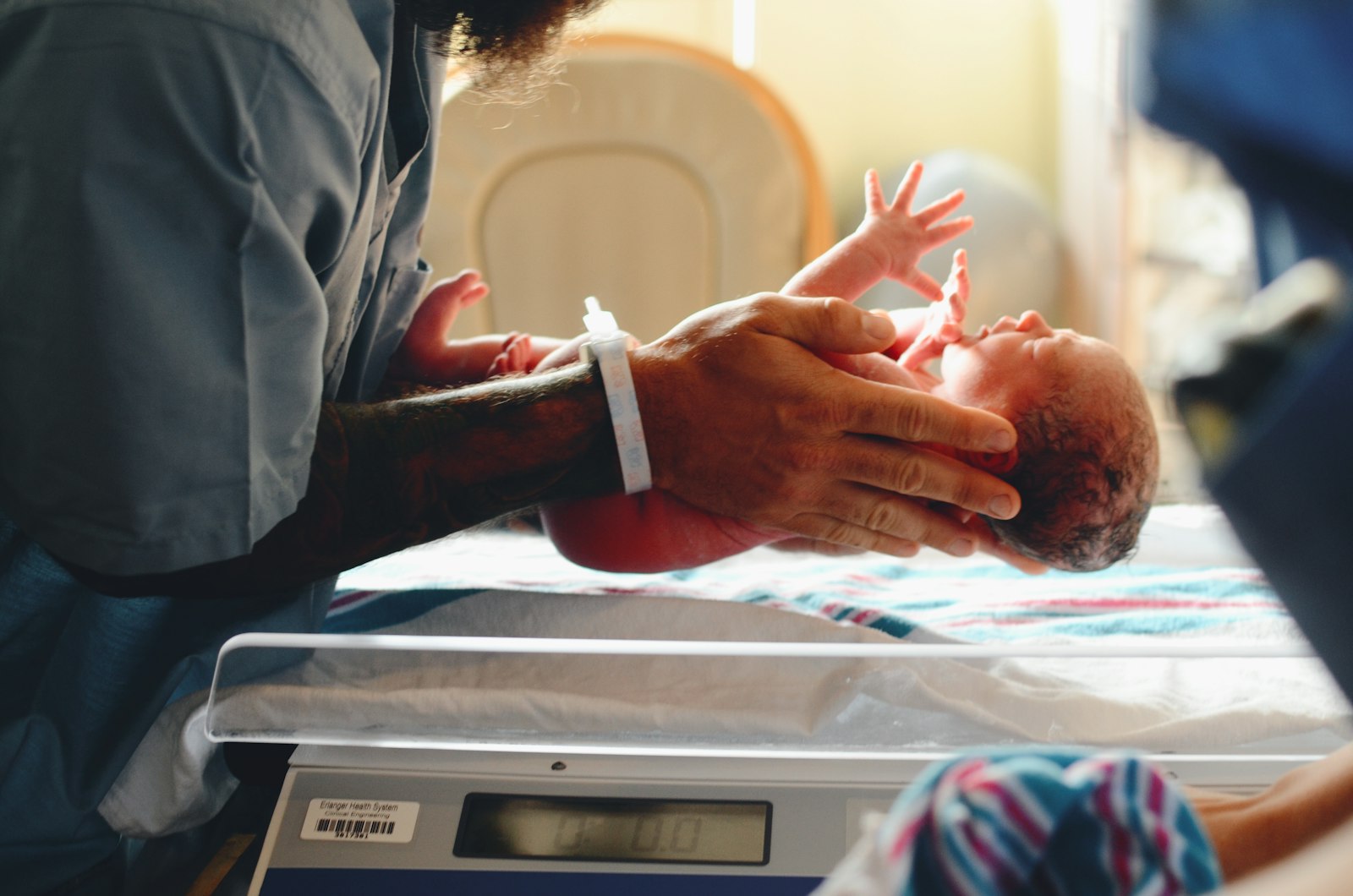 Newborn baby receiving a routine weight check after delivery